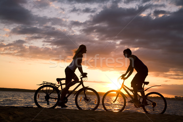 Strand Silhouetten Paar gegenüber andere Fahrräder Stock foto © pressmaster