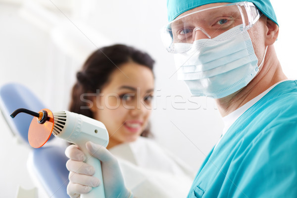 Profesional dentista sonriendo ultravioleta lámpara Foto stock © pressmaster