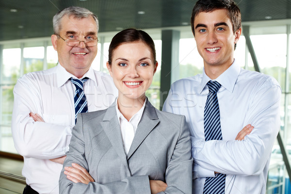Negócio grupo de trabalho três sorridente pessoas de negócios olhando Foto stock © pressmaster
