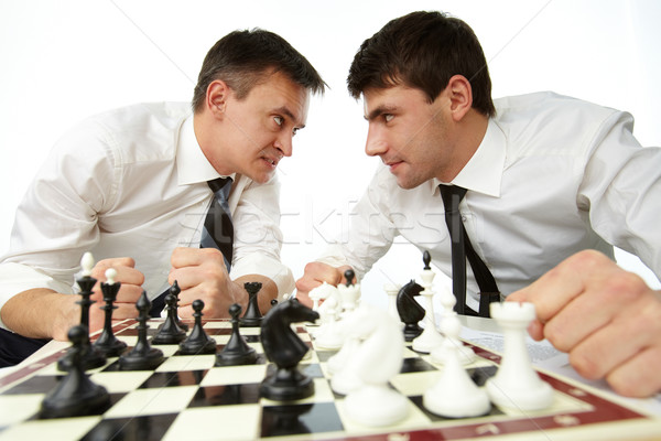Zangado dois homens olhando outro jogar xadrez Foto stock © pressmaster
