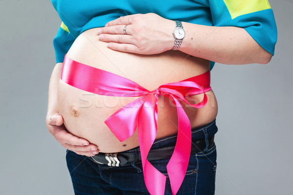 Pregnant belly with pink ribbon. Stock photo © prg0383