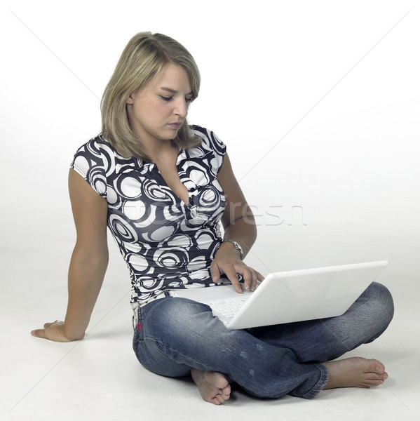 relaxed young girl sitting on the ground while computing Stock photo © prill