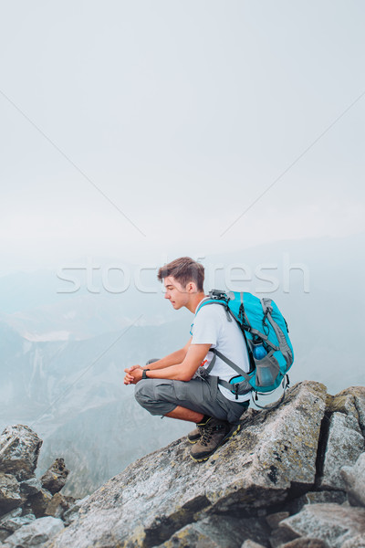 Boy sitting on a mountain peak Stock photo © przemekklos