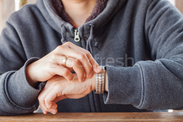 Woman checks the time on a wrist watch Stock photo © punsayaporn