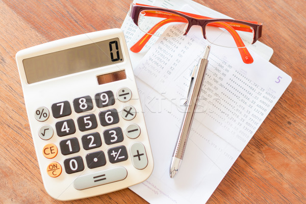 Top view of calculator, pen, eyeglasses and bank account passboo Stock photo © punsayaporn