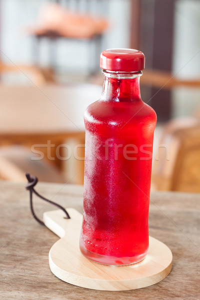 Red syrup in the bottle on wooden plate Stock photo © punsayaporn