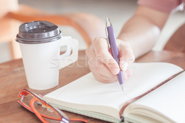 Woman writing on notepaper Stock photo © punsayaporn