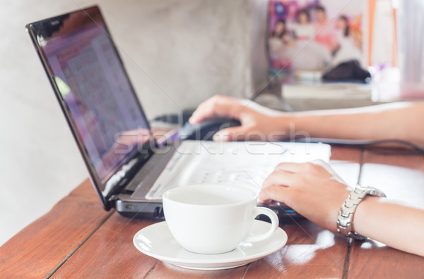 Vrouw met behulp van laptop beker koffie voorraad foto Stockfoto © punsayaporn