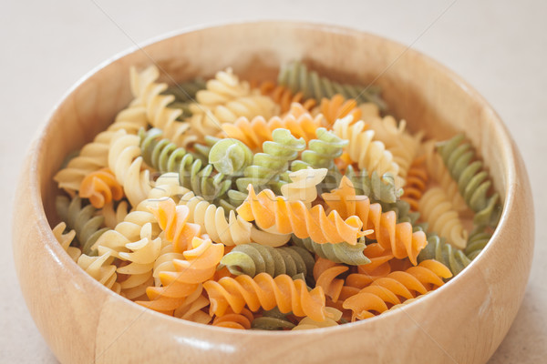 Raw fusilli pasta on wooden bowl Stock photo © punsayaporn