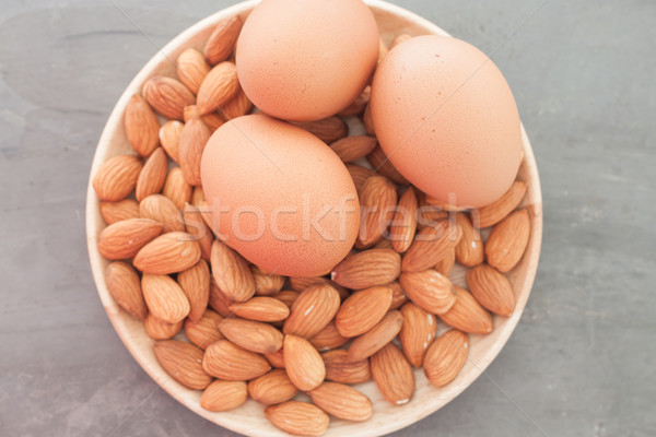 Almond nuts and eggs on wooden plate Stock photo © punsayaporn