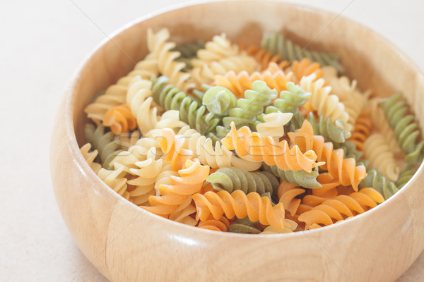 Raw fusilli pasta on wooden bowl Stock photo © punsayaporn