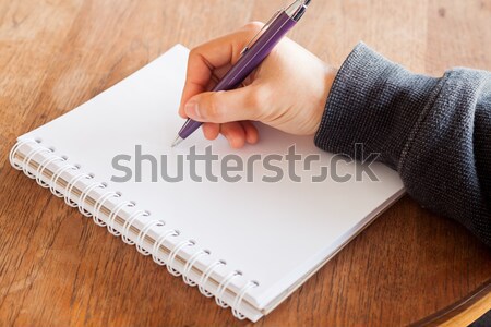 Woman hand with pen writing on notebook Stock photo © punsayaporn