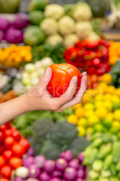 Stock photo: Woman holding red tomato in supermarket