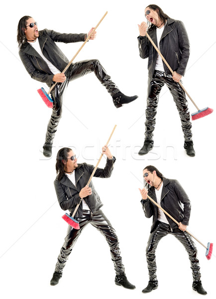 Caucasian man playing broom like guitar against white background. Stock photo © pxhidalgo