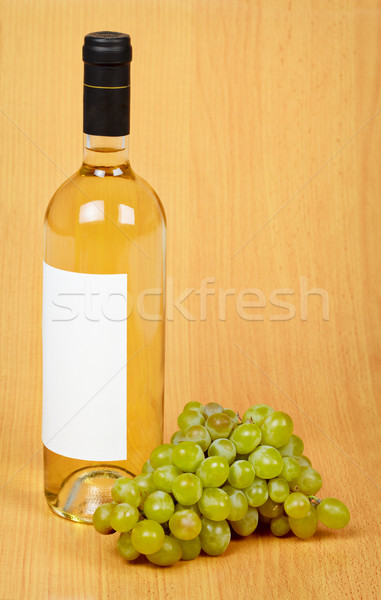 Still life - bottle of white wine and grapes on wooden surface Stock photo © pzaxe