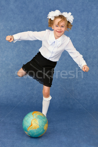 Schoolgirl kicks globe as footballer Stock photo © pzaxe
