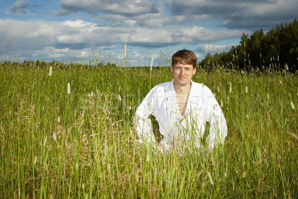 Young man in white kimono sits in grass Stock photo © pzaxe