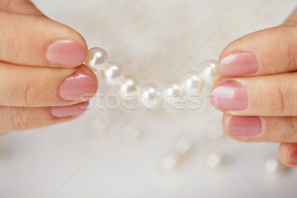 Female fingers hold thread with pearls Stock photo © pzaxe