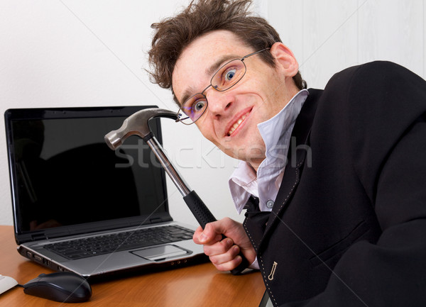 Businessman in spectacles gone mad with a hammer Stock photo © pzaxe