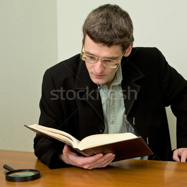 Guy in eyeglasses reads the book Stock photo © pzaxe