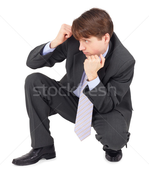 Young man sits in a defensive pose on white Stock photo © pzaxe