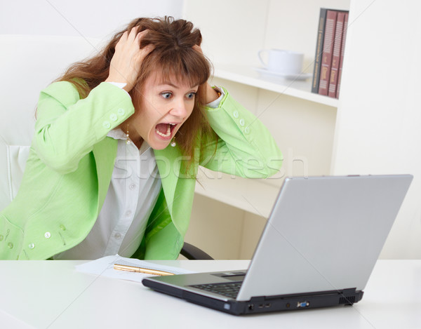 Enraged woman reads news in Internet Stock photo © pzaxe