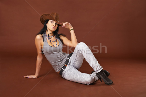 Girl in cowboy hat sitting on a brown Stock photo © pzaxe