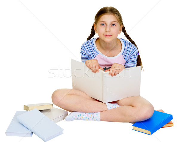 Stock photo: Girl sits among a heap of books