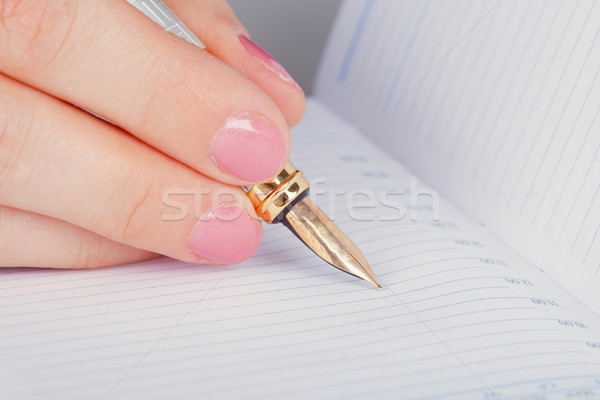 Golden pen and notebook Stock photo © pzaxe