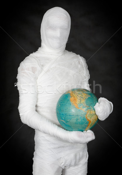 Man in costume mummy and terrestrial globe Stock photo © pzaxe