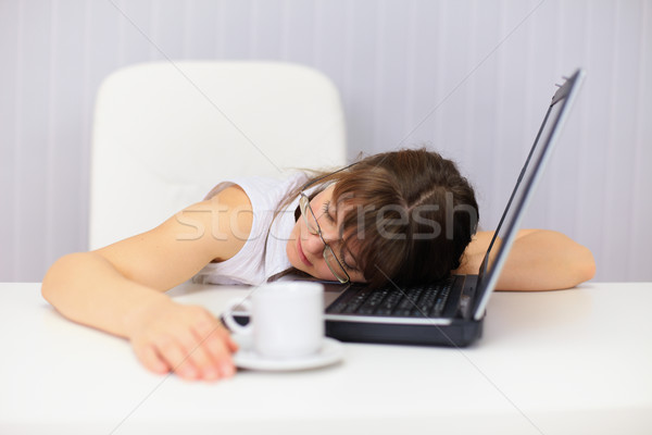 Young woman comically sleeps on laptop at office Stock photo © pzaxe