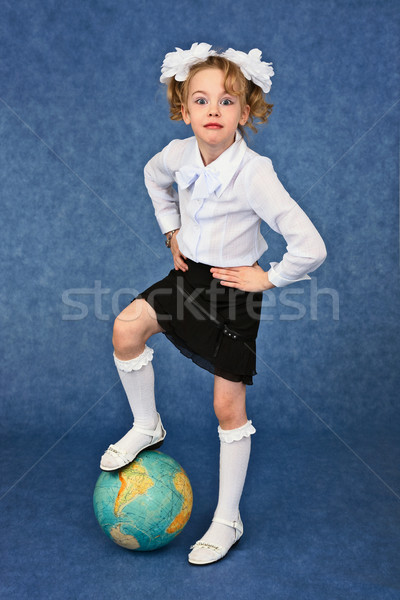Girl set foot on globe like a soccer ball Stock photo © pzaxe