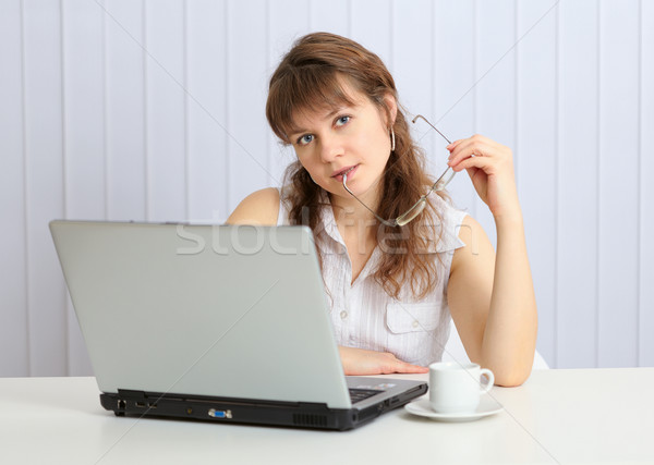 Stock photo: Beautiful young girl at table with laptop