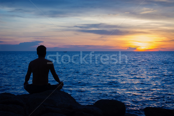 Stock photo: Young man practicing yoga on ocean shore