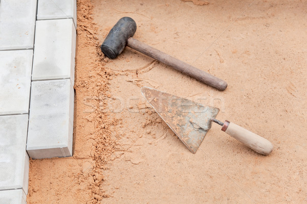 Tools of the mason on a sand - trowel and hammer Stock photo © pzaxe