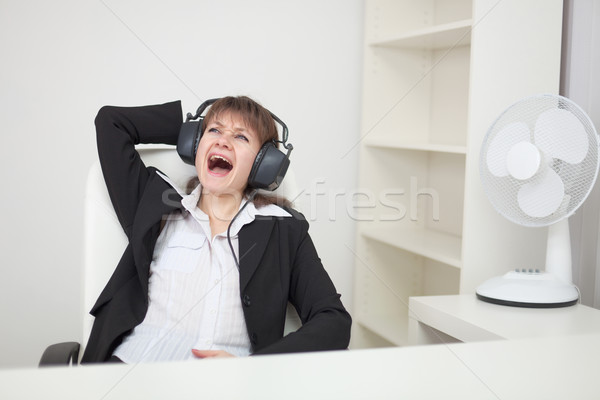 Girl funny sings sitting in an armchair at office Stock photo © pzaxe