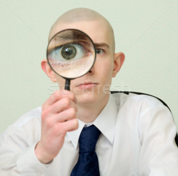 Guy looks through the big magnifier Stock photo © pzaxe