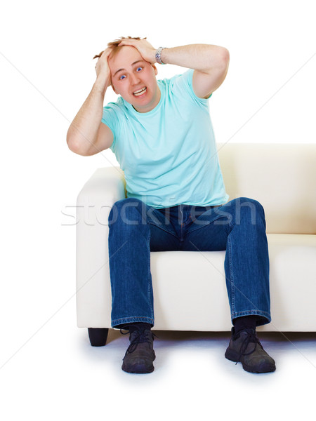 Nervous hysteria man at home on sofa isolated on white Stock photo © pzaxe