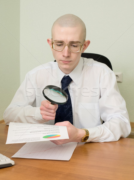 Boss with a magnifier on a workplace Stock photo © pzaxe
