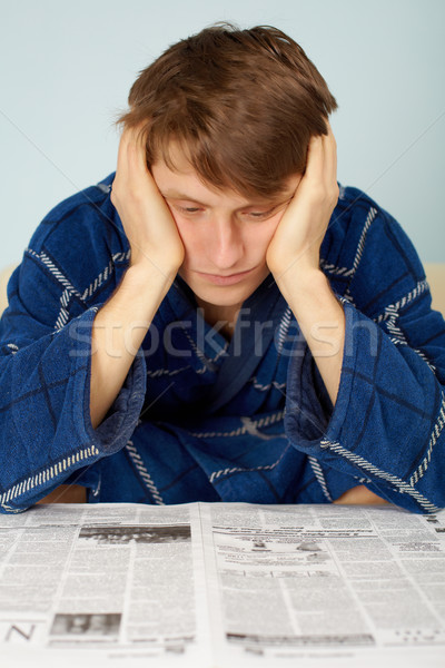 Stock photo: Sad man reading a newspaper