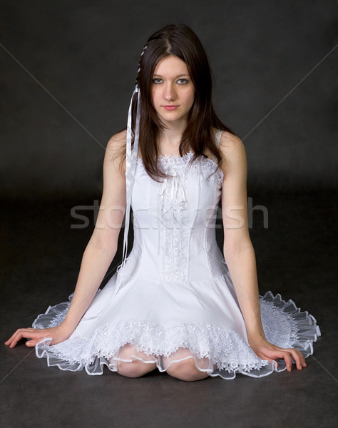 Girl in white dress sits on a black Stock photo © pzaxe