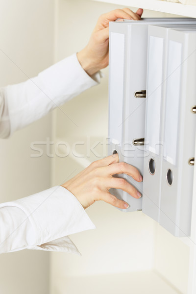 Hands of official remove from shelf a folder with classified doc Stock photo © pzaxe