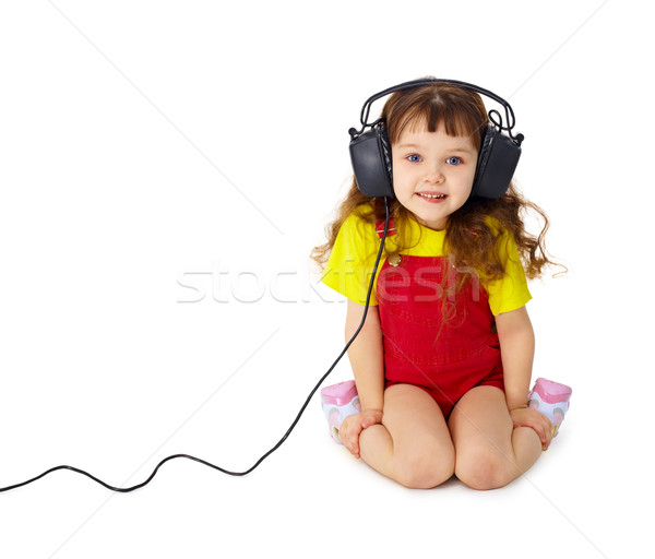 Child listens attentively to music on white Stock photo © pzaxe