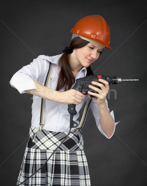Girl in a helmet learns to use a drill Stock photo © pzaxe