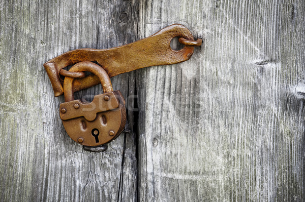 Old padlock on a wooden door Stock photo © pzaxe