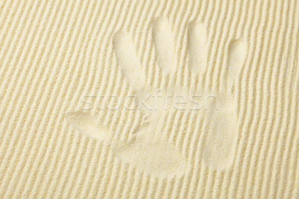 Stock photo: Trace from palm on surface of yellow sand