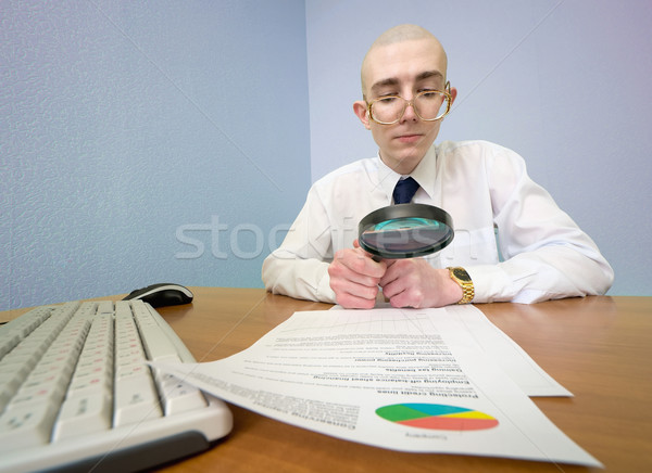 Boss with a magnifier on a workplace Stock photo © pzaxe