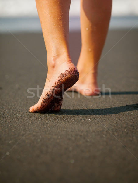 Wet, Black Sand on a Tourist's Foot at a Tropical Beach. Bali, I Stock photo © pzaxe