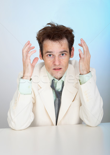 Young sorrowful man in white suit sits at table Stock photo © pzaxe