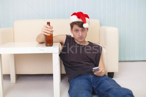 ストックフォト: 若い男 · クリスマス · 帽子 · 階 · ビール · テレビ